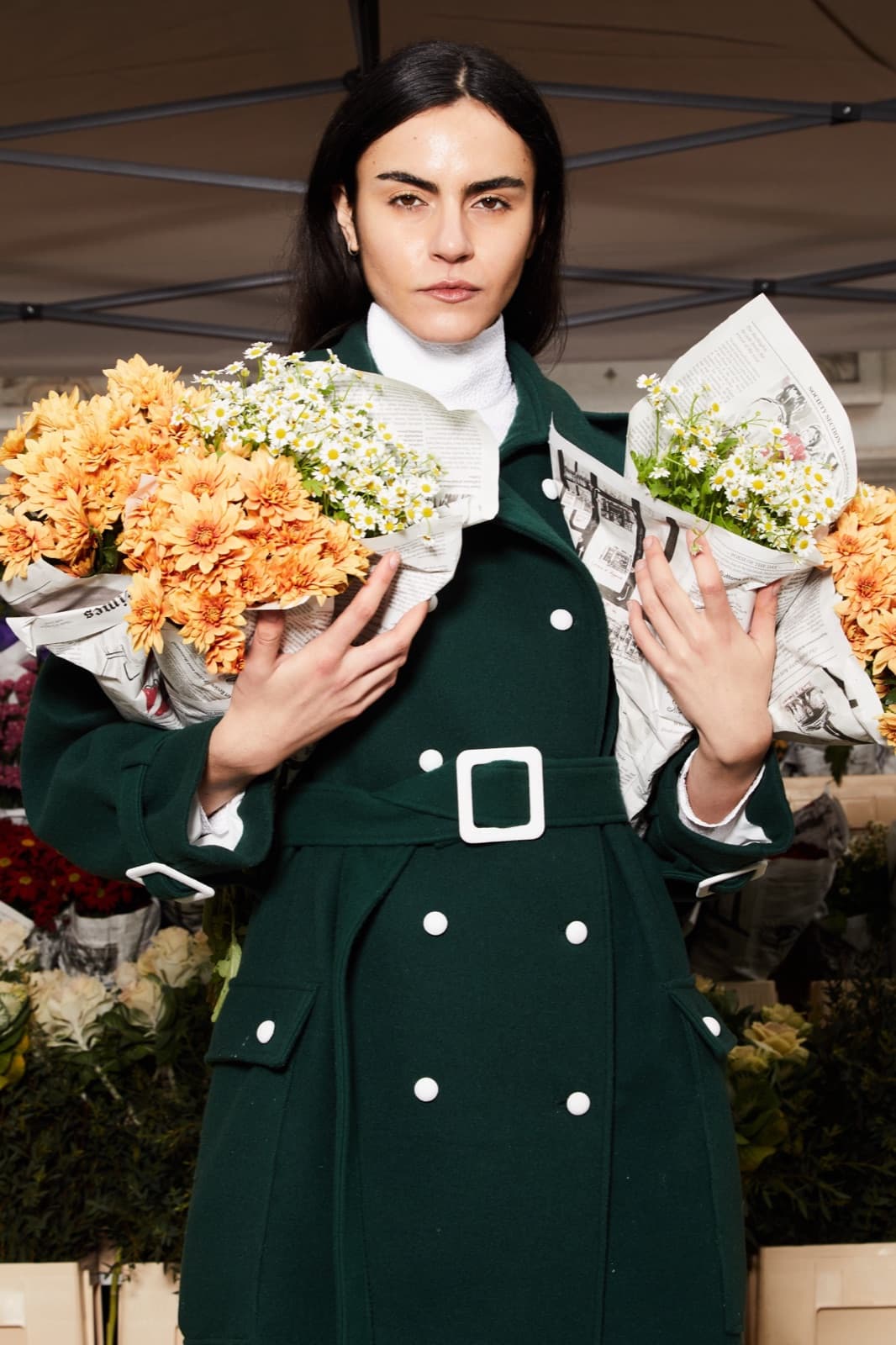 Sleek dark hair and a forest-green coat.